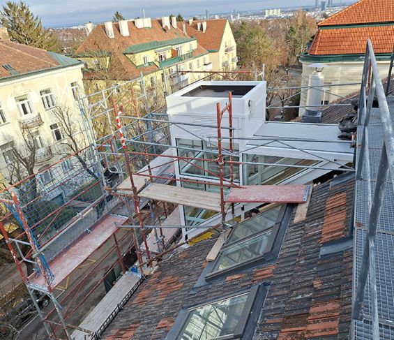 Verglaster Außenaufzug während der Montage auf dem Dach eines Gebäudes in Wien.